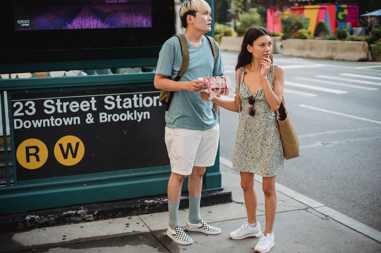 services-01 Full body of diverse couple standing with map while trying to find direction in city center during trip