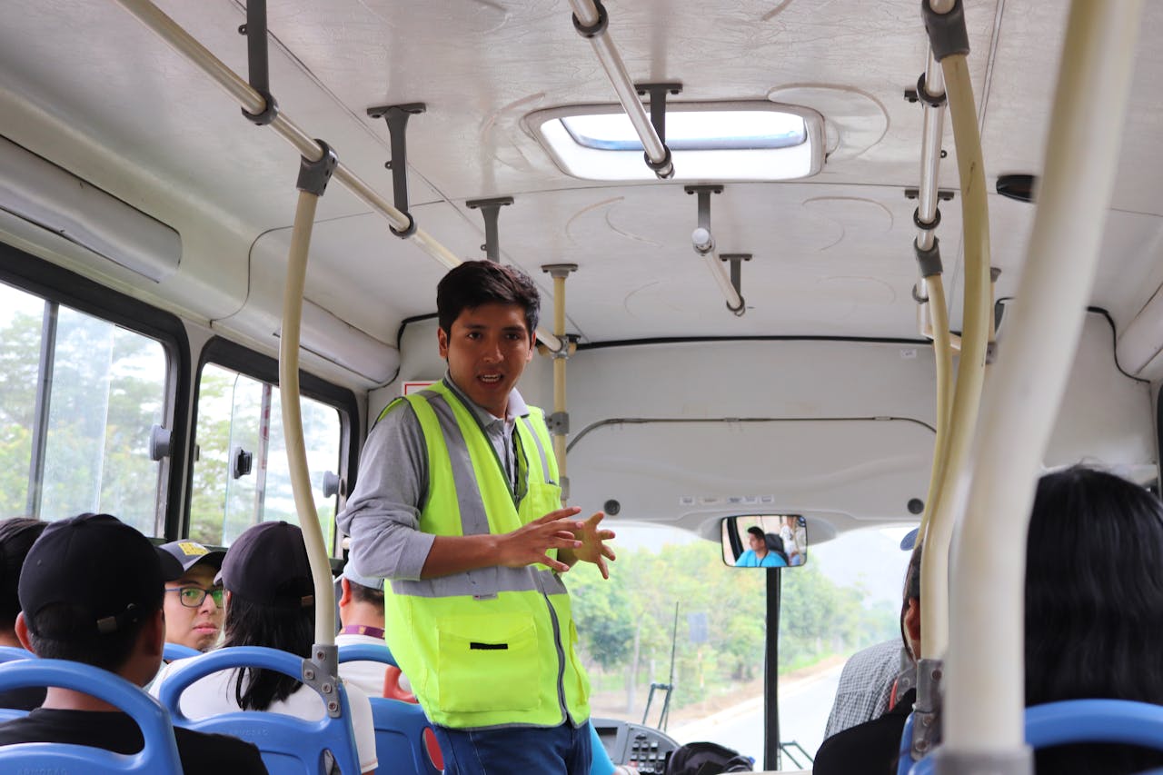 services-02 A tour guide on a bus in El Agustino, Lima, Perú, engaging with passengers.